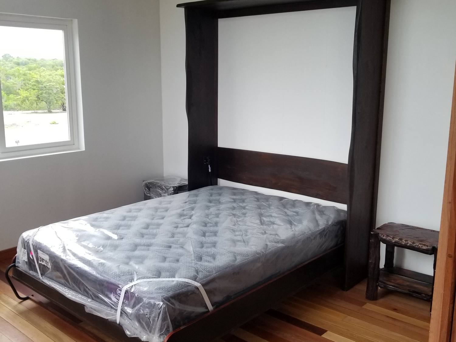 Custom hardwood Murphy bed folded down from its cabinet
